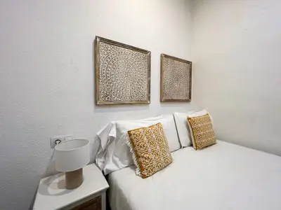 a white bed with three pillows on top of it at Stay U-nique Apartments Rossello in Barcelona