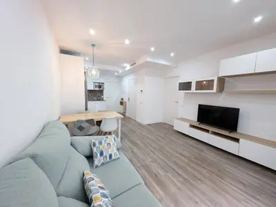 a living room with a blue couch and a television at New flat in the centre, 10 min from BCN Airport in Cornellà de Llobregat
