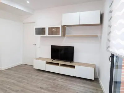 a living room with a flat screen tv on a wall at New flat in the centre, 10 min from BCN Airport in Cornellà de Llobregat