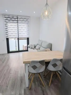 a living room with a table and chairs and a couch at New flat in the centre, 10 min from BCN Airport in Cornellà de Llobregat