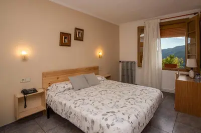 a bedroom with a bed and a window at Hostal Montserrat in Montseny