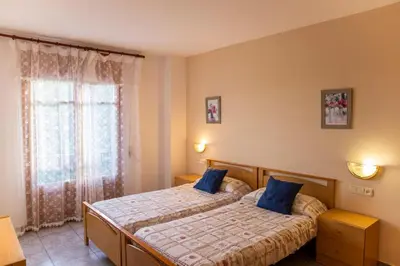 a bedroom with a bed with blue pillows and a window at Hostal Montserrat in Montseny
