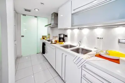 a kitchen with white cabinets and a sink at Victoria City Center Barcelona in Barcelona
