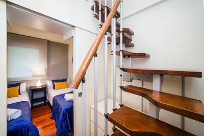 a small room with two beds and a staircase at Victoria City Center Barcelona in Barcelona