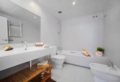 a white bathroom with a sink and a toilet at Victoria Diagonal Mar Barcelona in Barcelona