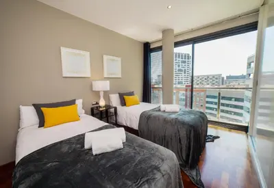 two beds in a room with a large window at Victoria Diagonal Mar Barcelona in Barcelona