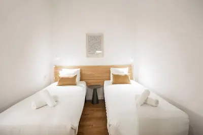 two beds in a room with white walls at Fantástico piso en Barcelona in Barcelona