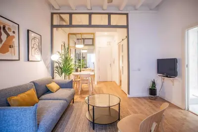 a living room with a blue couch and a table at Fantástico piso en Barcelona in Barcelona