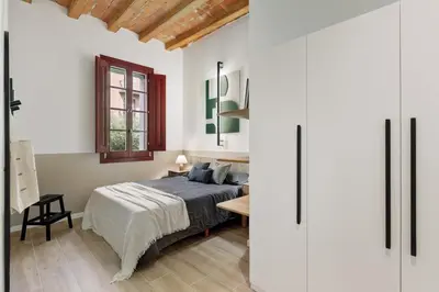 a bedroom with a bed and a table with a lamp at Castell - 2 bedrooms and balcony in Sant Antoni in Barcelona