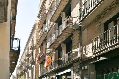 a building with balconies and a flag on it at Cathedral Ramblas Apartment in Barcelona