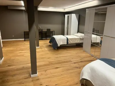 a room with two beds and a wooden floor at esplugues de llobregat in Barcelona
