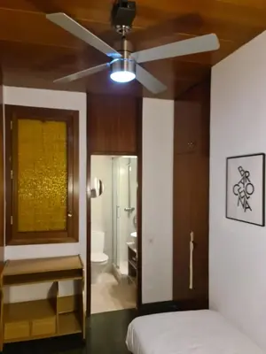 a bedroom with a ceiling fan and a bathroom at Josep Tarradellas 80 in Barcelona