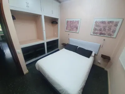a bedroom with a white bed with a black pillow at Josep Tarradellas 80 in Barcelona