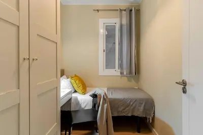a small bedroom with a small bed and a window at Canela Homes BARCELONA SANT PAU in Barcelona