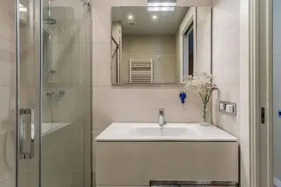 a white bathroom with a sink and a shower at Canela Homes BARCELONA SANT PAU in Barcelona