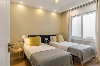 two beds in a room with a window at Canela Homes BARCELONA SANT PAU in Barcelona