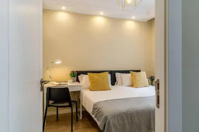 a bedroom with a bed and a desk with a chair at Canela Homes BARCELONA SANT PAU in Barcelona