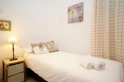 a bedroom with two beds with white sheets and a lamp at Gracia Travesera 2 Bedrooms Renovated Apartment in Barcelona