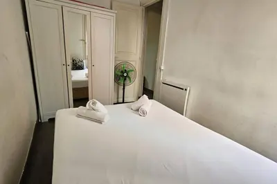 a bedroom with a white bed and a mirror at Romantic 19th century apartment in Barcelona