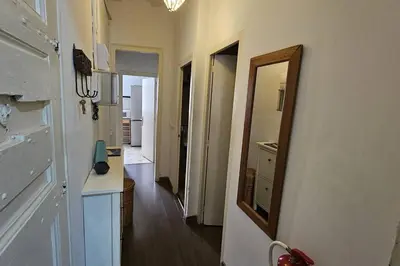 a hallway with a mirror on the wall and a hallway with a kitchen at Romantic 19th century apartment in Barcelona