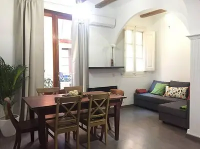 a living room with a table and chairs and a couch at Romantic 19th century apartment in Barcelona