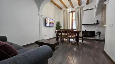 a living room with a couch and a table and chairs at Romantic 19th century apartment in Barcelona
