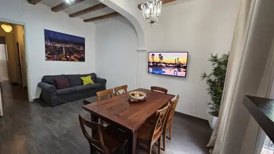 a dining room with a table and a couch at Romantic 19th century apartment in Barcelona