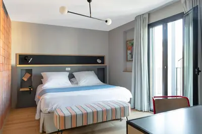 a bedroom with a bed and a desk and a table at Hotel Brummell in Barcelona