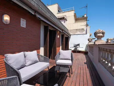 a patio with two chairs and a couch on a balcony at Habitas Stay Barcelona in Barcelona