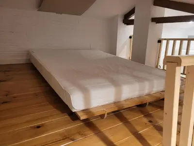 a large bed in a room with a wooden floor at Cal 2 de Maig in Vilafranca del Penedès