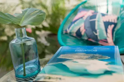 a glass bottle sitting on a table next to a book at SmartRoom Barcelona in Barcelona