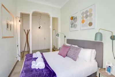 a bedroom with a white bed with purple sheets and pillows at Passeig Sant Joan in Barcelona
