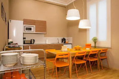 a kitchen with a table with chairs and plates on it at Born Barcelona Hostel in Barcelona