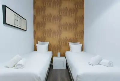 two twin beds in a room with white sheets at Canela Homes BARCELONA VALÈNCIA in Barcelona