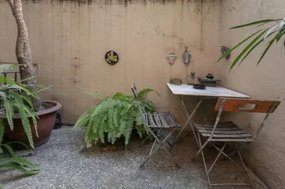 a table and chair next to a wall with plants at Canela Homes BARCELONA CLASSIC in Barcelona