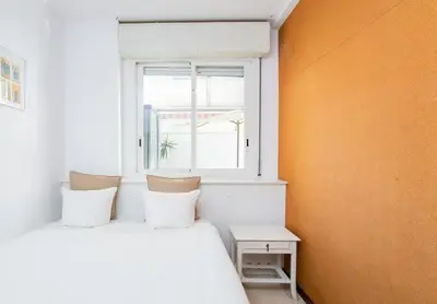 two white beds in a room with a window at Canela Homes BARCELONA MONUMENTAL in Barcelona