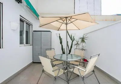 a table and chairs with a table and an umbrella at Canela Homes BARCELONA MONUMENTAL in Barcelona