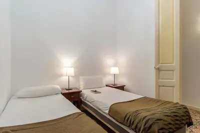 two beds in a room with two lamps on tables at Canela Homes BARCELONA PATIO in Barcelona