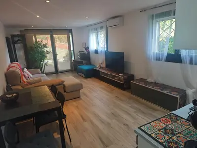 a living room with a couch and a tv at INSPIRA MAISON Montaña y Mar in Teià