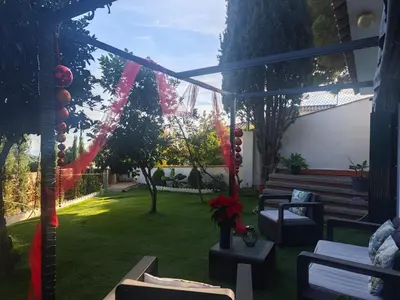 a patio with a lawn with chairs and a garden at INSPIRA MAISON Montaña y Mar in Teià