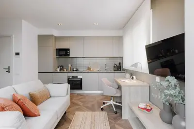 a living room with a white couch and a kitchen at Casa Plaza in Barcelona