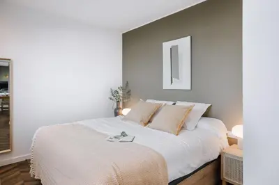 a bedroom with a large bed with white sheets at Casa Plaza in Barcelona