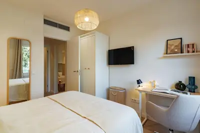 a bedroom with a bed and a desk and a chair at Casa Tamarita in Barcelona