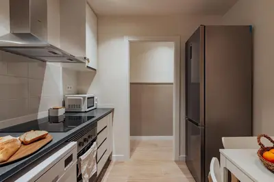 a kitchen with a refrigerator and some bread on the counter at Casa Tamarita in Barcelona