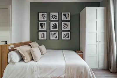 a bedroom with a bed with four pictures on the wall at Casa Tapiz in Barcelona