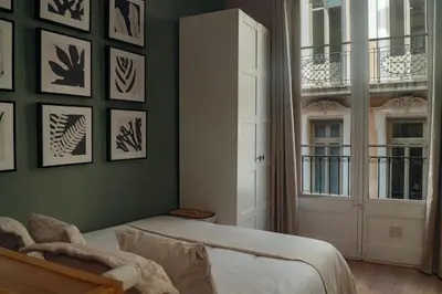 a bedroom with a bed and a window and a door at Casa Tapiz in Barcelona