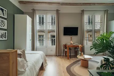 a bedroom with a bed and a desk with a television at Casa Tapiz in Barcelona