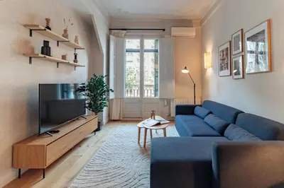 a living room with a blue couch and a tv at Casa Atlas in Barcelona