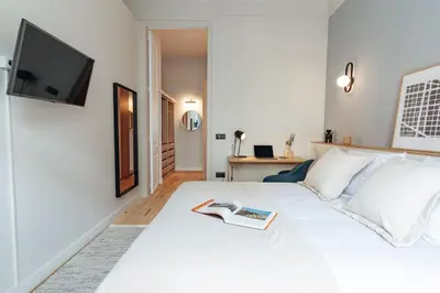 a bedroom with a white bed with a book on it at Casa Atlas in Barcelona