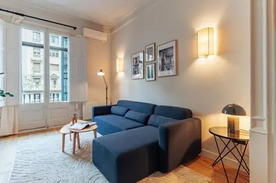a living room with a blue couch and a table at Casa Atlas in Barcelona